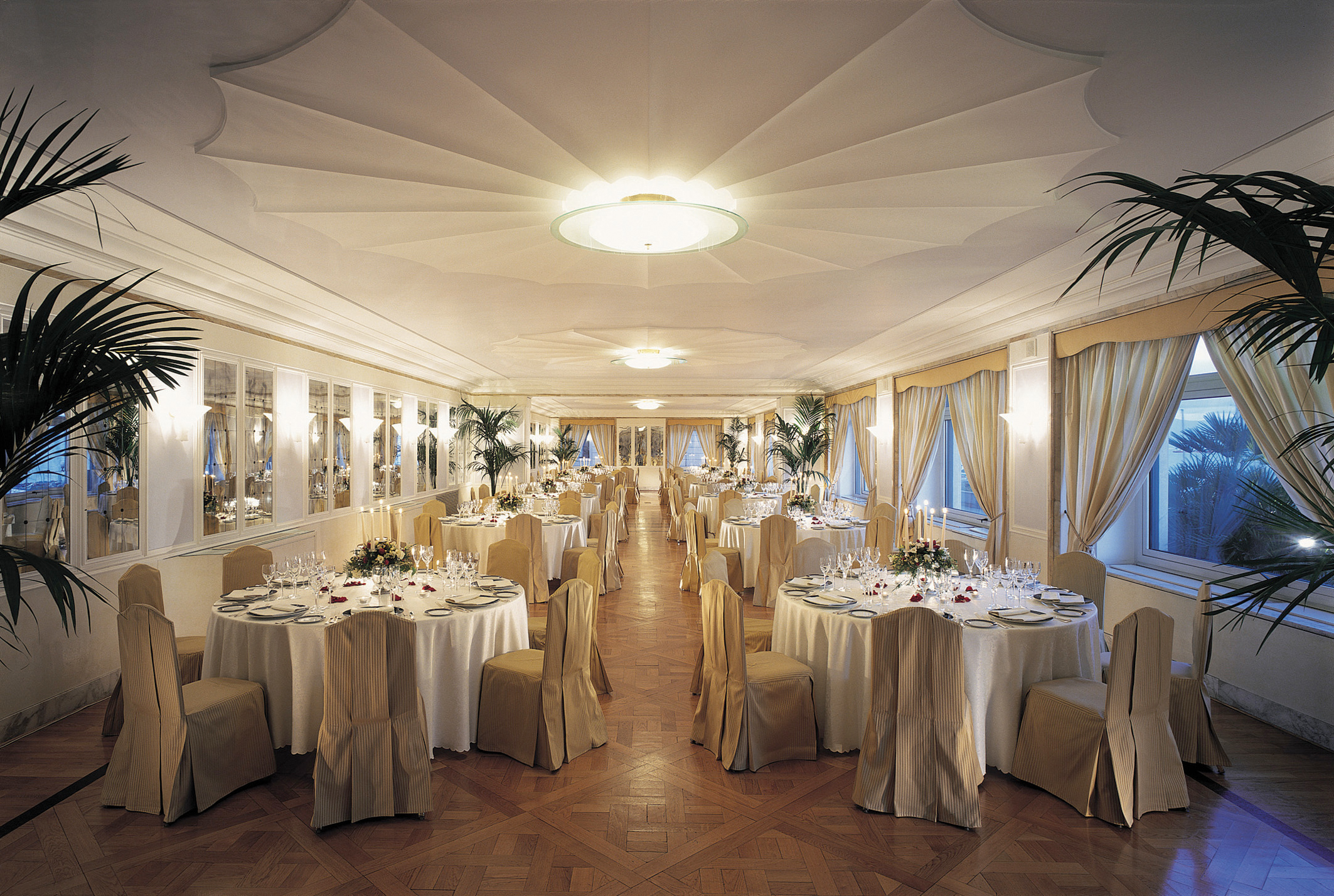 Dining room set up with large circular tables and elegant table cloths