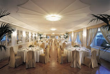 Dining room set up with large circular tables and elegant table cloths