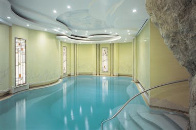 Indoor swimming pool with yellow walls and wall lights