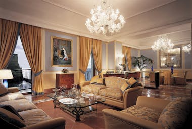 Lounge with large chandeliers, sofas and draping gold curtains