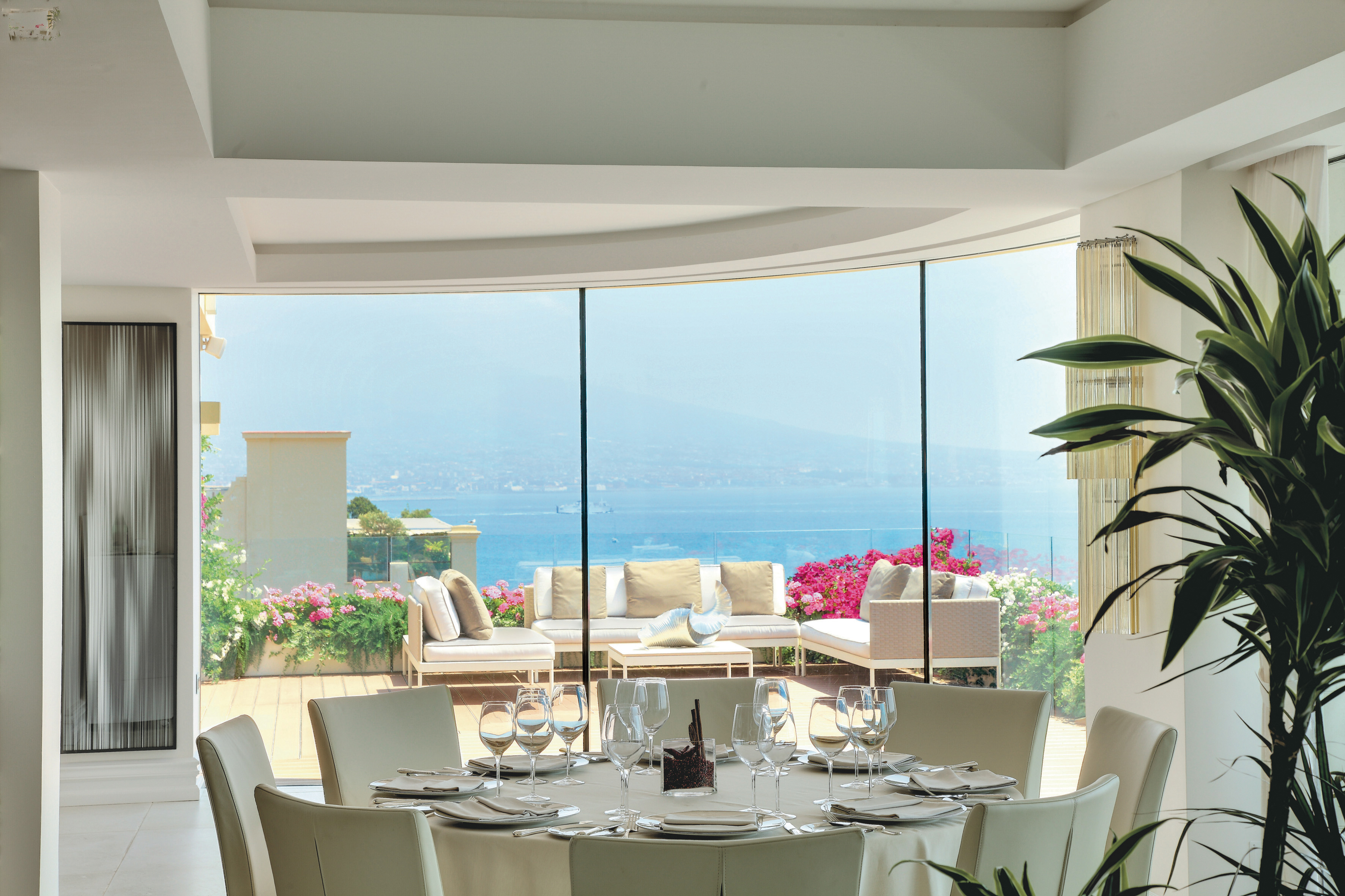 Indoor restaurant seating area with large windows showing view of mountain and water