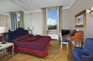 Aldrovandi Villa Borghese Rome executive suite bedroom bed desk mirrored wall open window