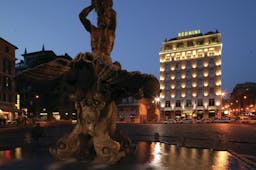 Bernini Bristol Rome hotel exterior at night hotel lit up fountain in foreground
