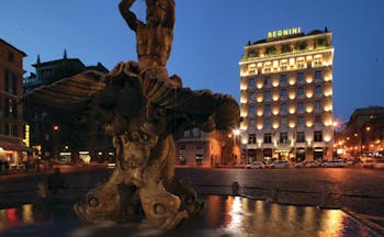Bernini Bristol Rome hotel exterior at night hotel lit up fountain in foreground