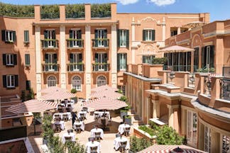 Hotel de la Villa Rome orange building with green shutter and umbrellas