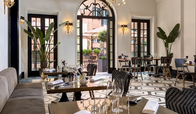 Hotel de la Villa Rome dining room with mosaic floor and tall plants