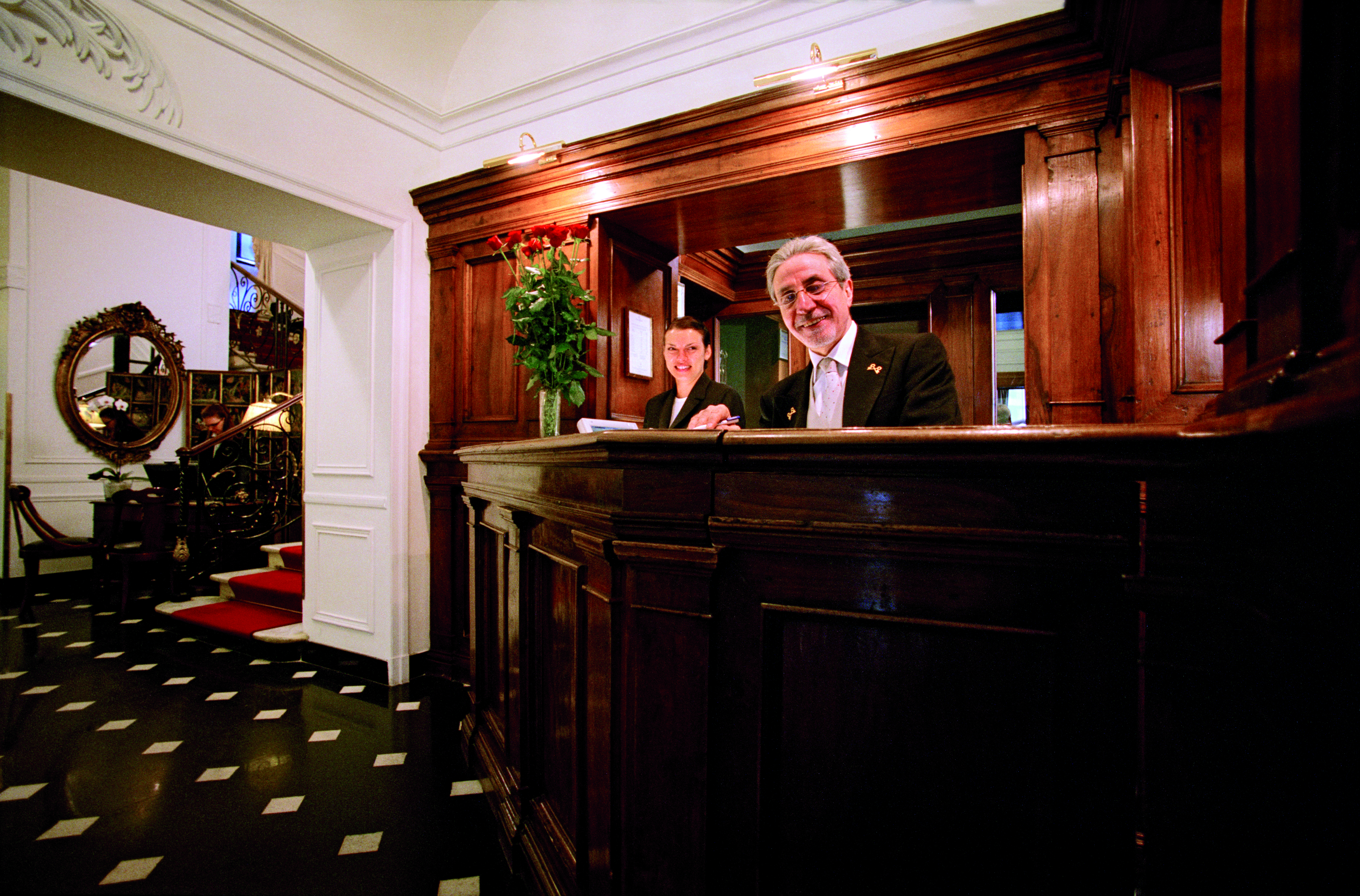 Hotel d'Inghilterra Rome reception desk antique furniture smiling hotel managers