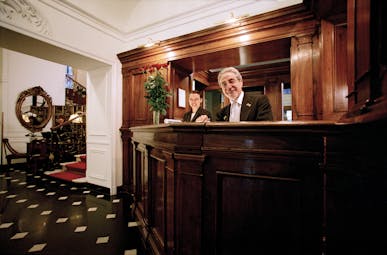 Hotel d'Inghilterra Rome reception desk antique furniture smiling hotel managers