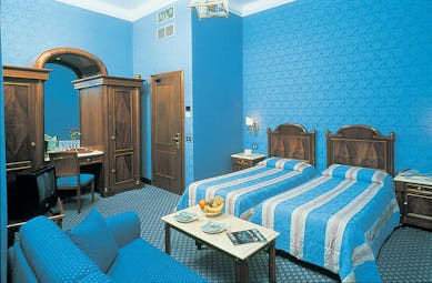 Twin bedroom with blue colour scheme, two single beds and a dressing table