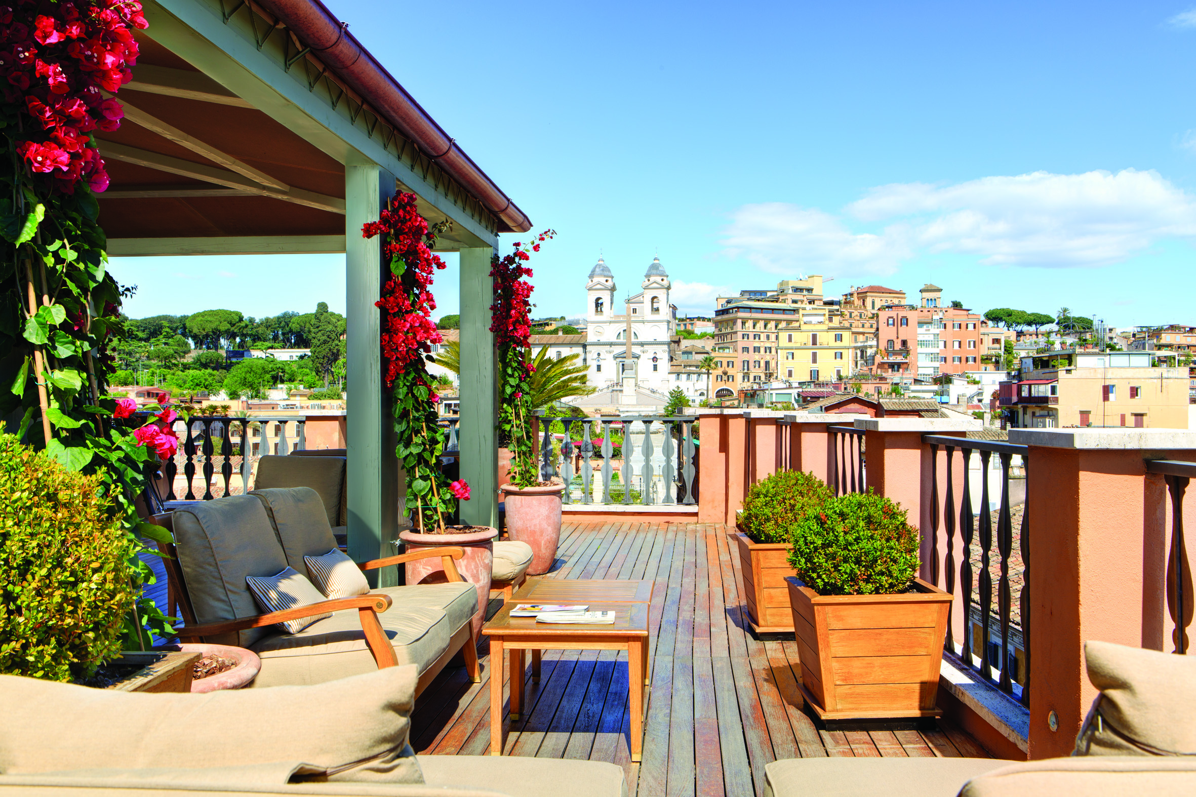 Hotel Portrait Roma rooftop bar with comfortable sofas, shady awning, and views across Rome