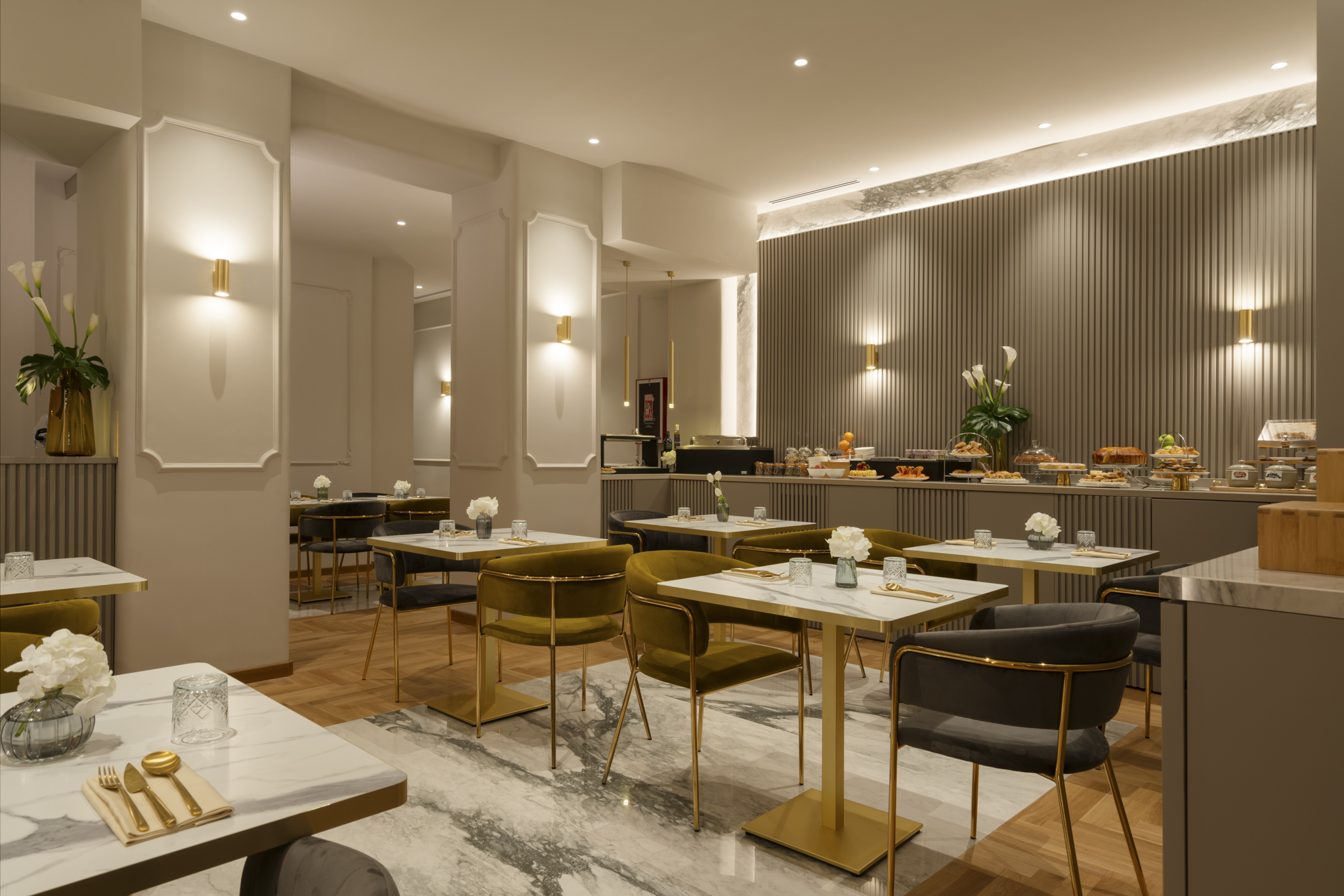Palazzo Venere breakfast buffet with gold and grey chairs and tables, marble tabletops, and gold cutlery