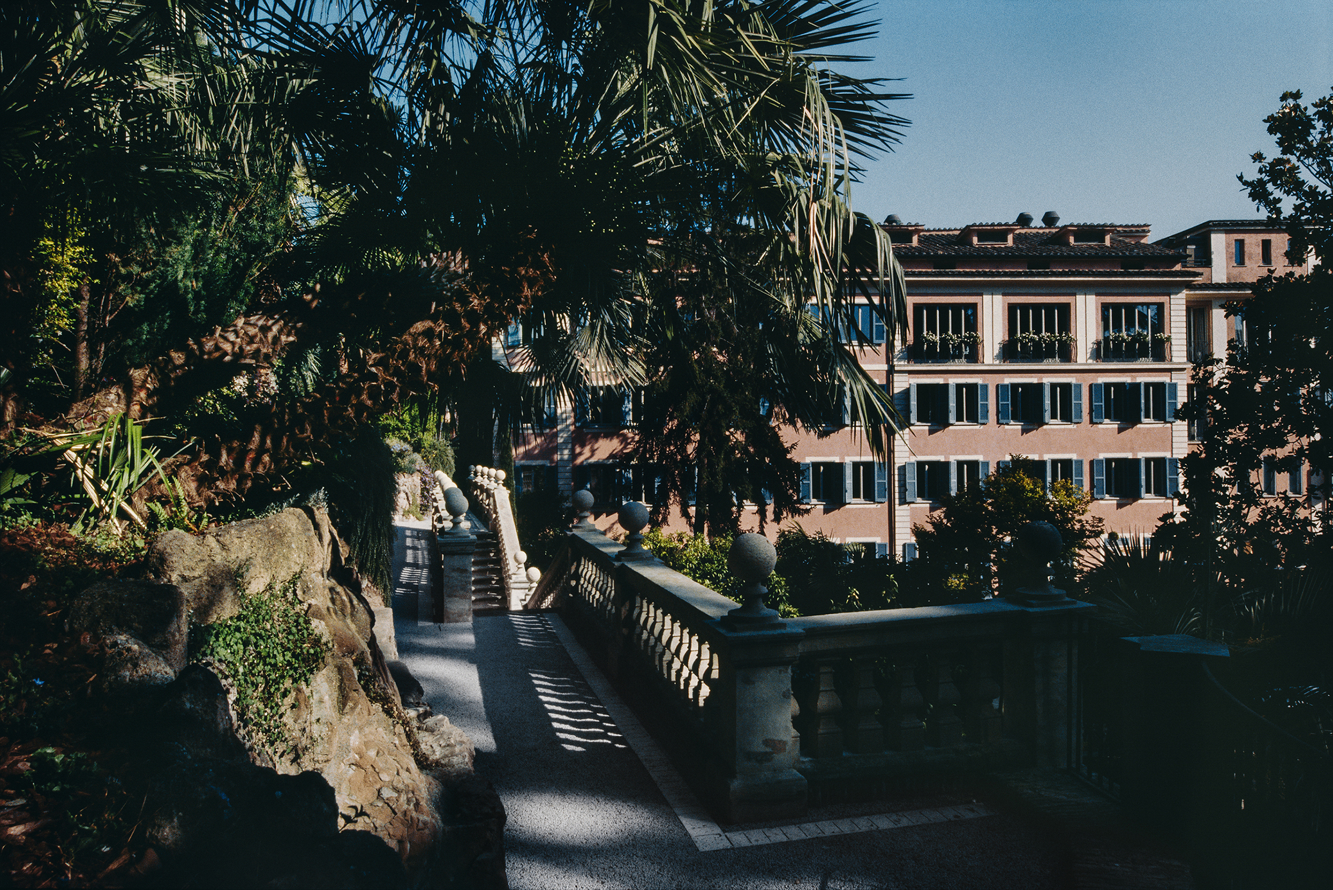 Hotel de Russie Rome garden with palms and pink building