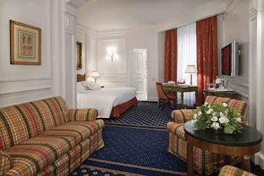 Grand Hotel Sitea Turin junior suite with striped sofa and orange curtains