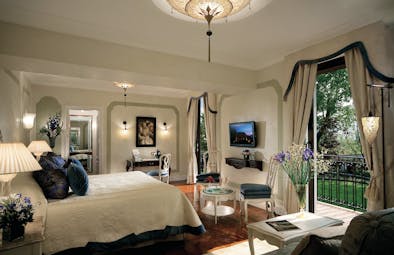 Belmond Hotel Cipriani Suite with king sized met, double doors leading out onto a balcony and a chandelier