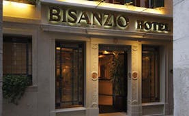 Entrance to the Bisanzio Hotel with the sign lit up in black above the wooden door