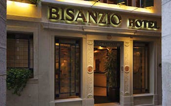 Entrance to the Bisanzio Hotel with the sign lit up in black above the wooden door