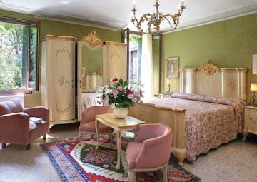 Bedroom with pink and green colour scheme, chandelier and double bed 