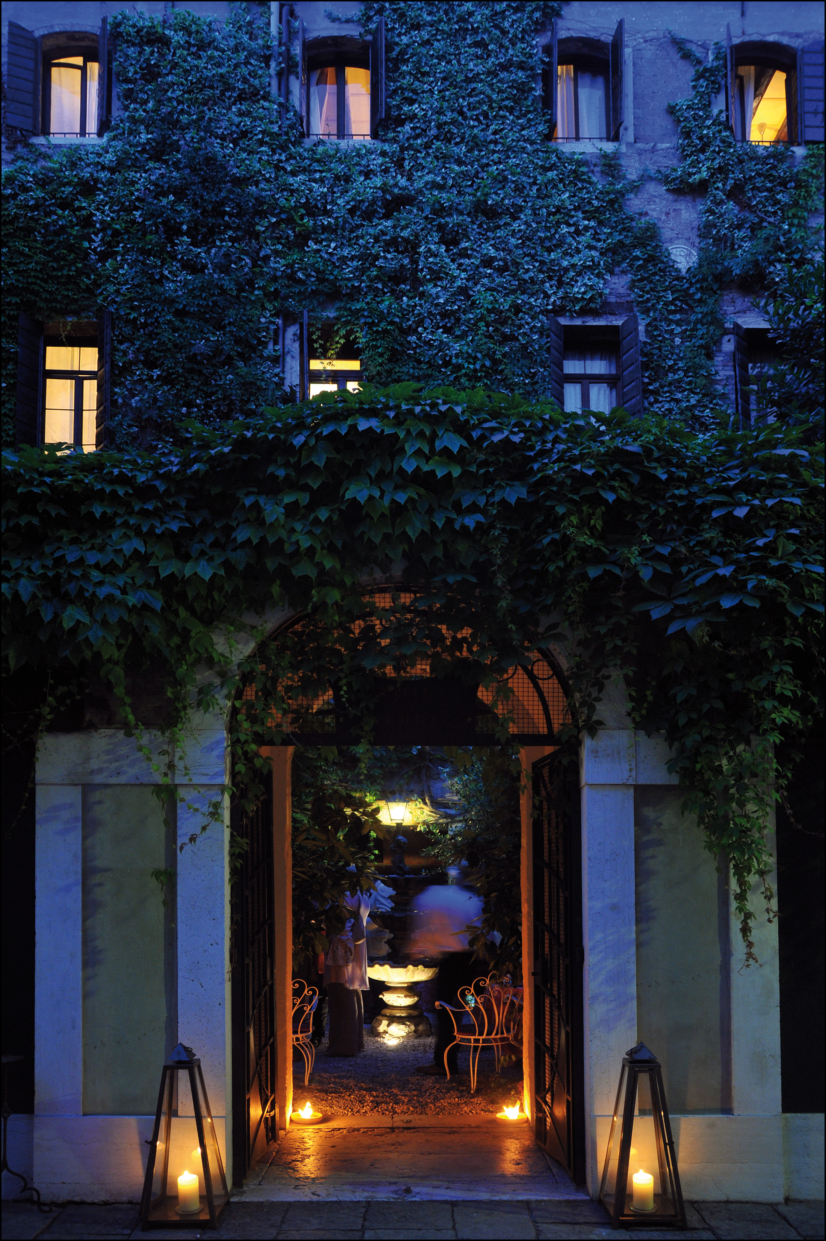 Entrance to Hotel Flora at dusk with vines creeping up the hotel walls and a large arch doorway