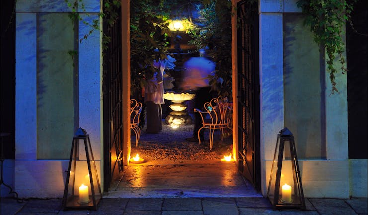 Entrance to Hotel Flora at dusk with vines creeping up the hotel walls and a large arch doorway
