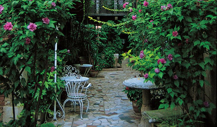 Hotel Flora Venice garden patio outdoor seating area shrubs