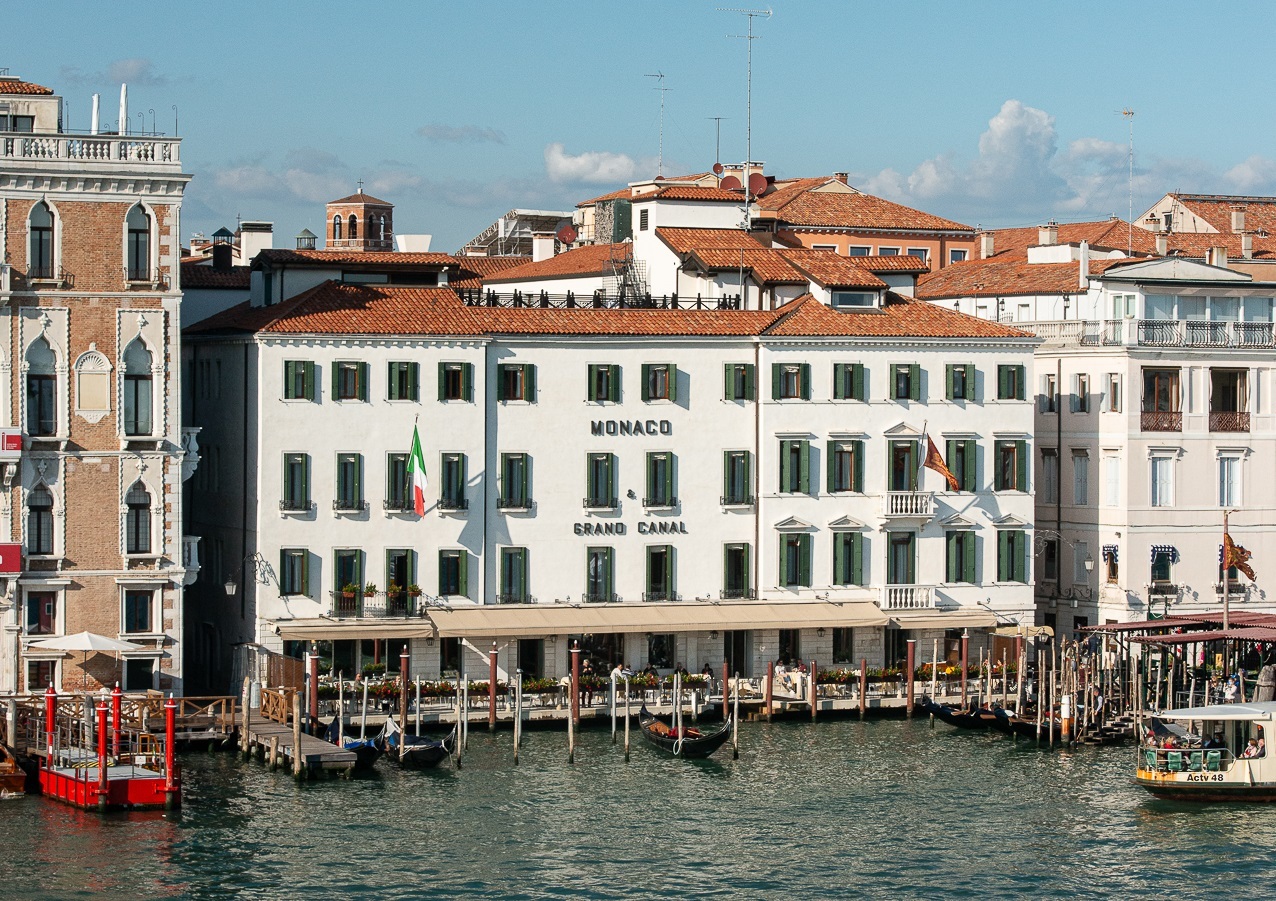 Hotel Monaco & Grand Canal exterior view, seen from the Grand Canal, showing the hotel with white facade, four stories of windows, and terracotta roof