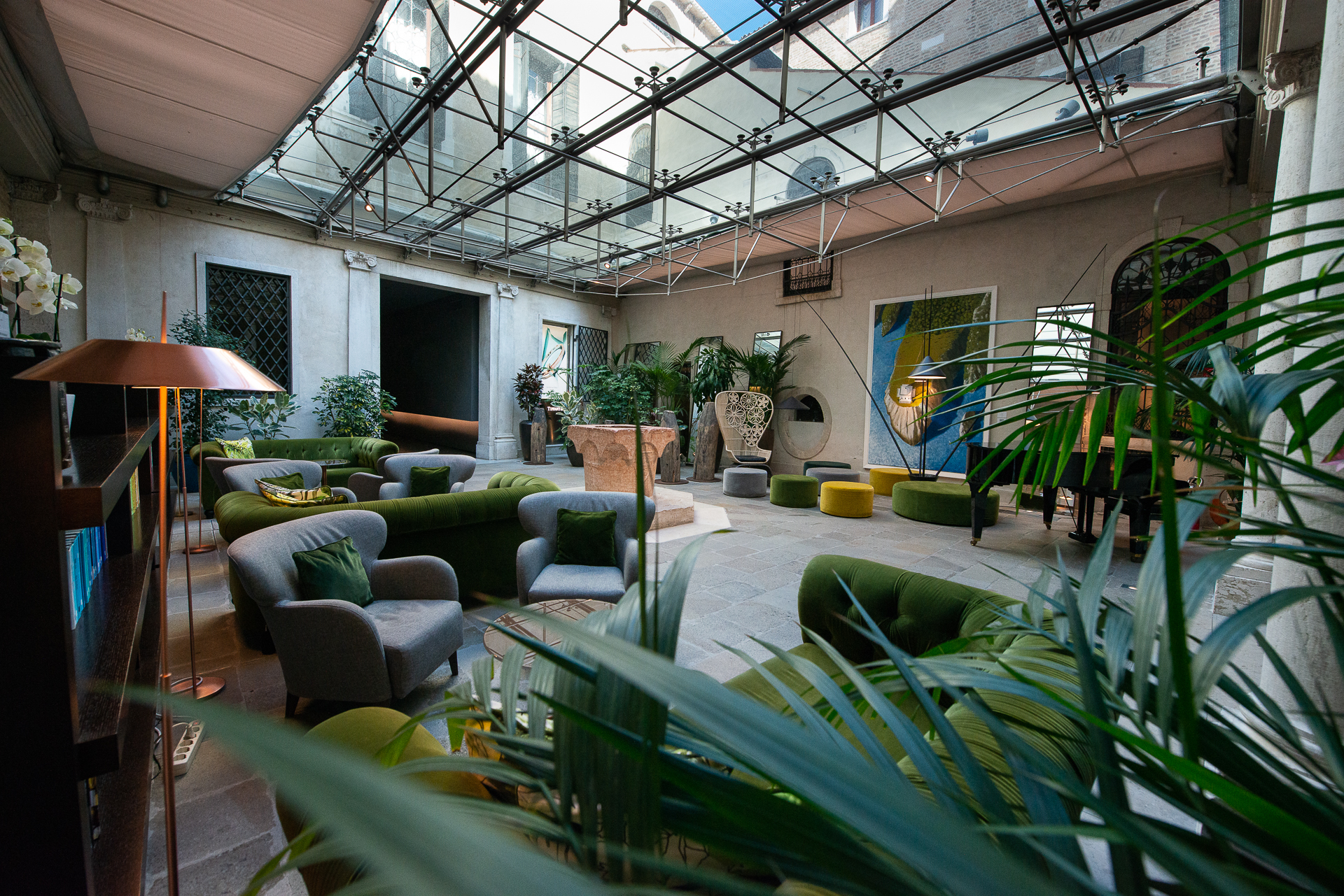Hotel Monaco & Grand Canal lobby with glass roof, and a green, jungle theme captured by green soft furnishings and many plants