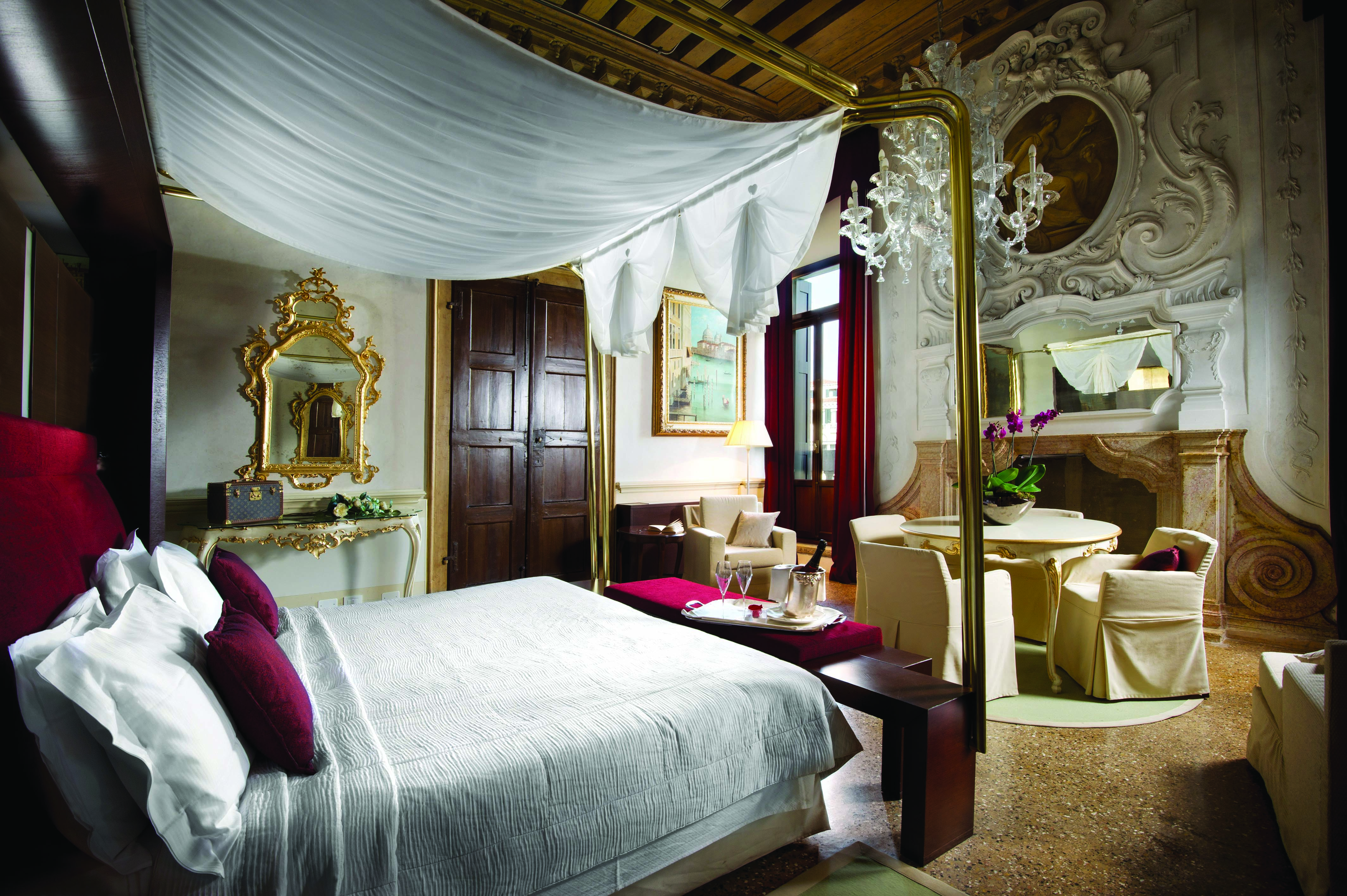 Palazzo Giovanelli Venice Foscarini suite large bed and room dining area ornately decorated
