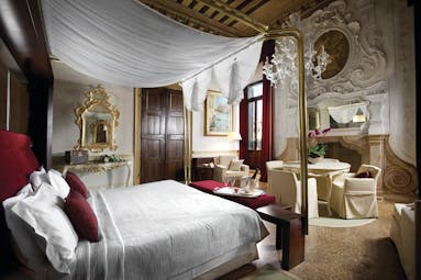 Palazzo Giovanelli Venice Foscarini suite large bed and room dining area ornately decorated