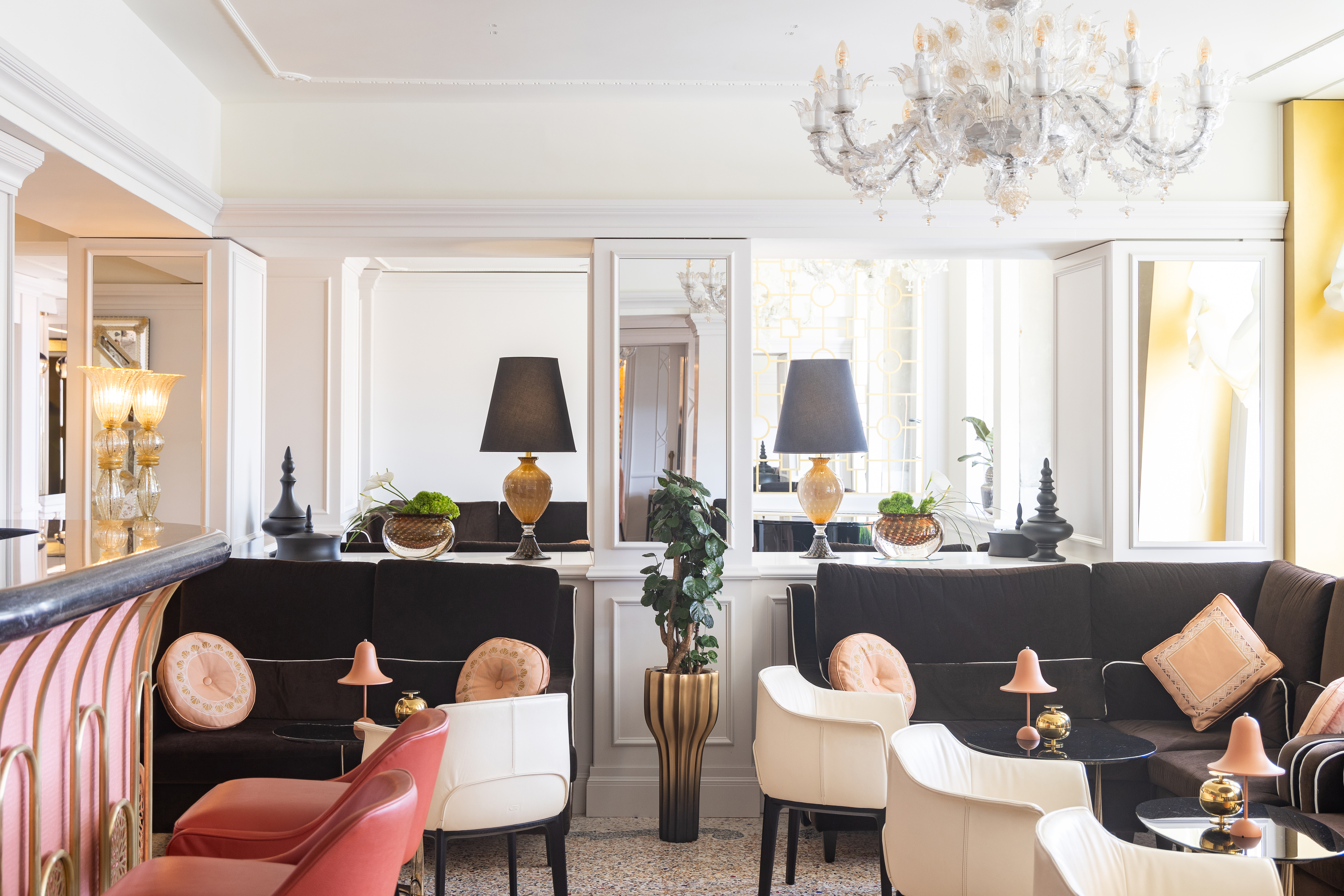 Londra Palace Venezia Bar, with comfortable booths, a pink bar with pink stools, and chandelier