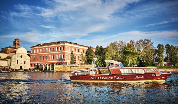 San Clemente Palace Venice hotel exterior view from canal boat on water