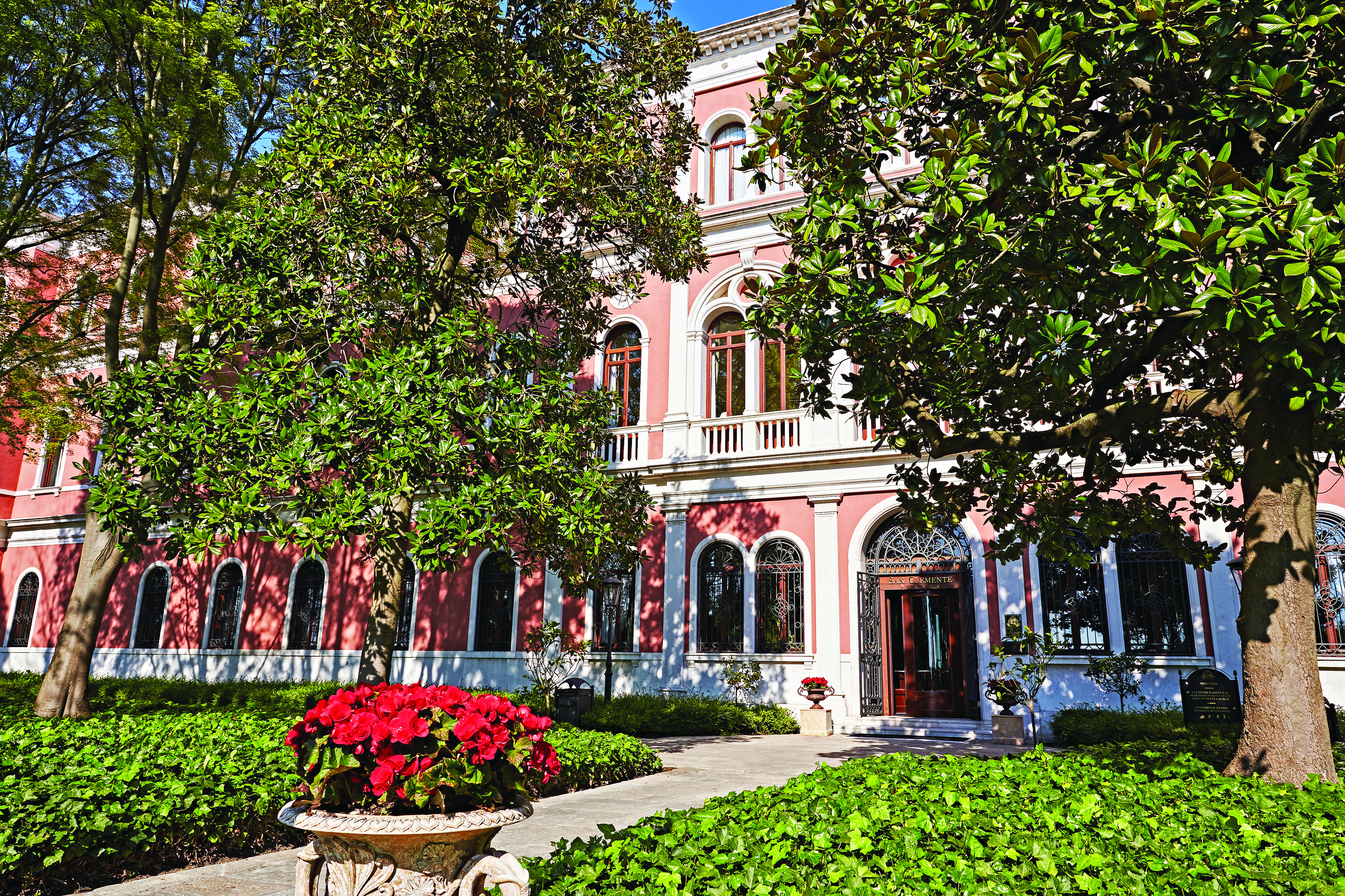 San Clemente Palace Venice hotel exterior pink building trees and shrubbery