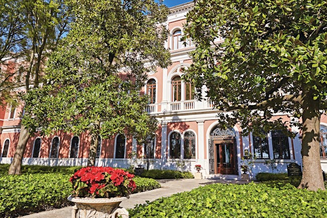 San Clemente Palace Venice hotel exterior pink building trees and shrubbery