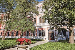 San Clemente Palace Venice hotel exterior pink building trees and shrubbery