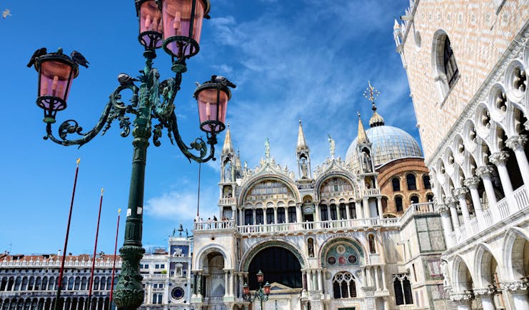 Iron lamp outside St Mark's Basilica and pink Doge's Palace in Venice
