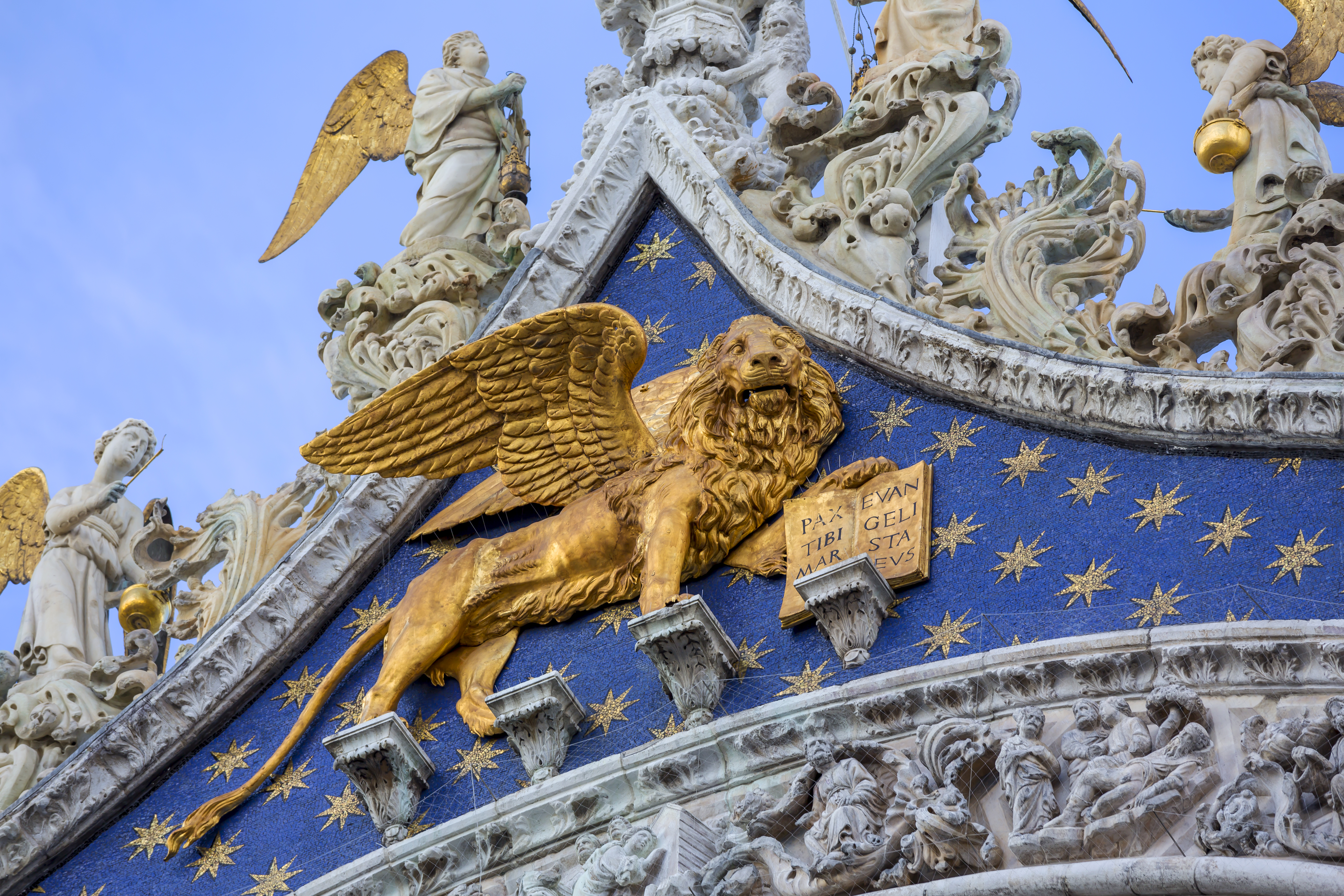 Golden lion on front of the blue and gold of St Mark's Basilica in Venice