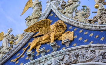 Golden lion on front of the blue and gold of St Mark's Basilica in Venice