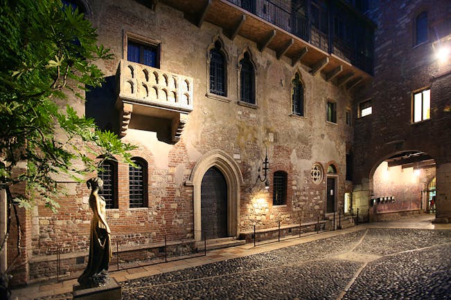 Hotel exterior of big stone building, large arching entrance door 