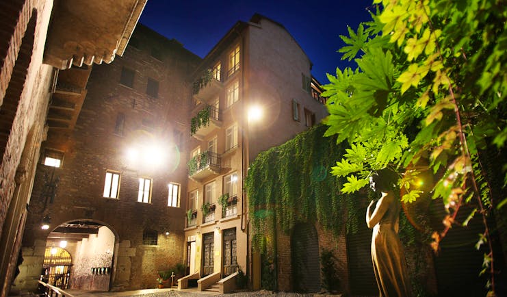 View of hotel from outside at dark with trees and vines outside
