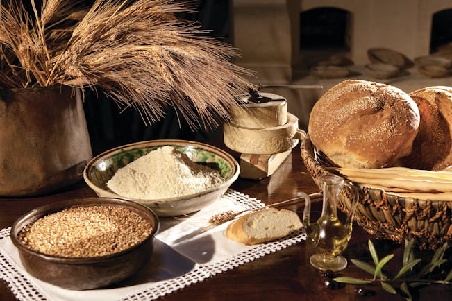 Rounds of bread and bowls of grain on table