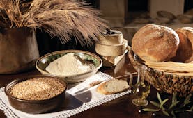 Rounds of bread and bowls of grain on table