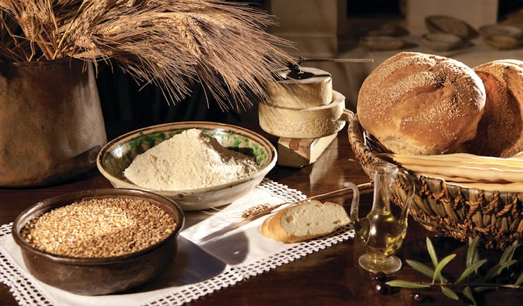 Rounds of bread and bowls of grain on table