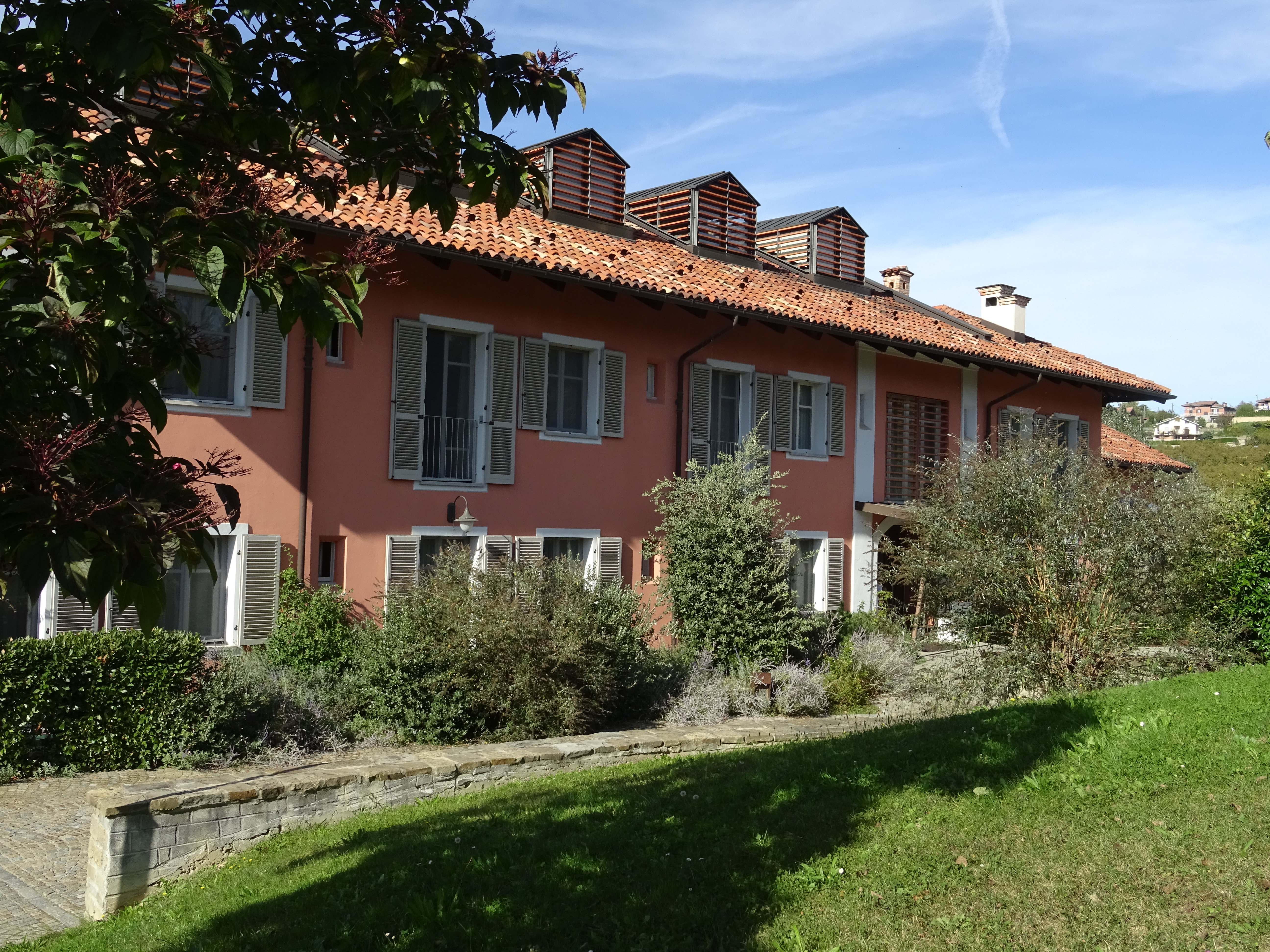 Pink low building with green shutters Villa d'Amelia Piemonte