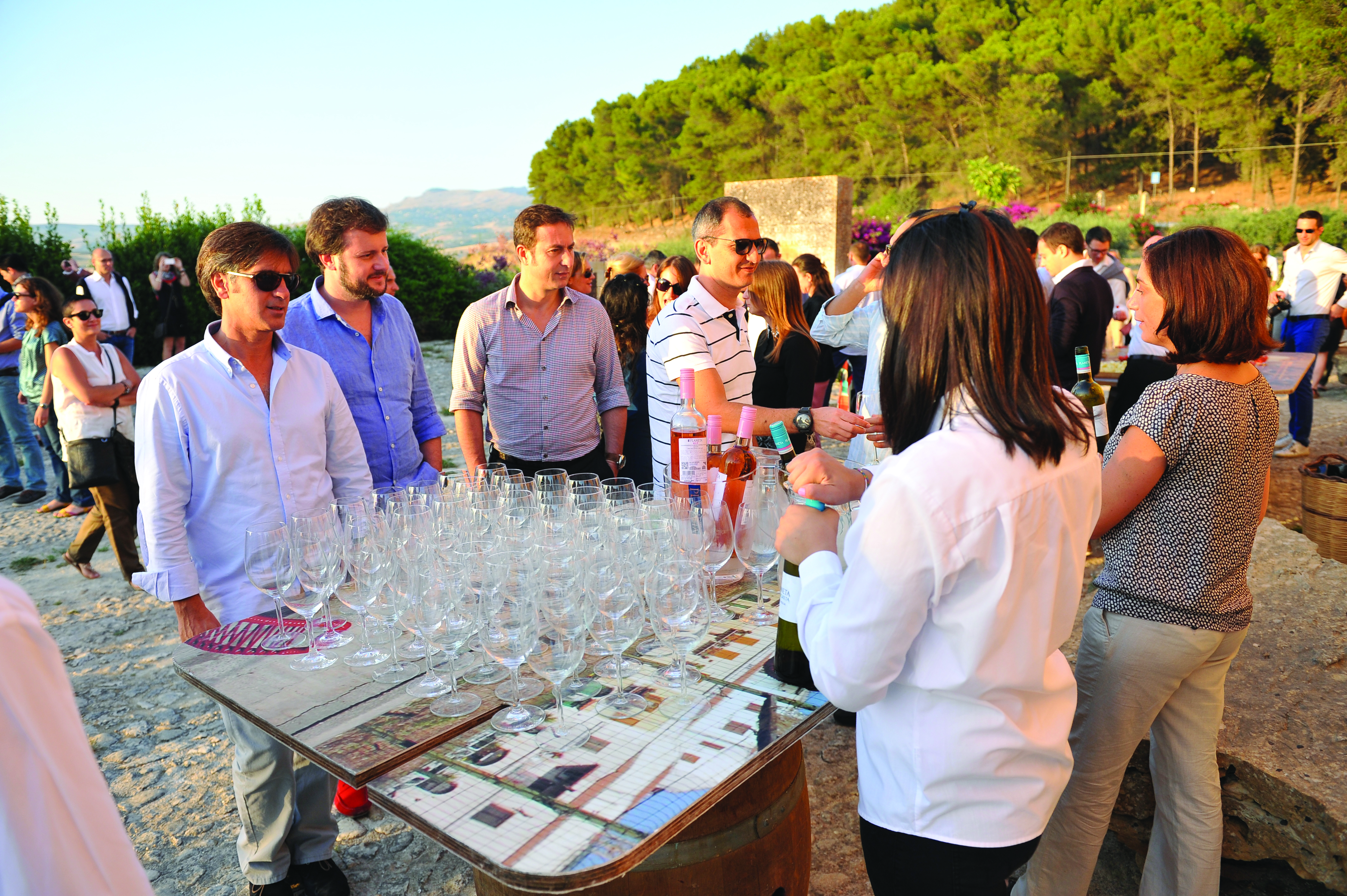 Group of people outside with table of glasses ready for wine tastingt at Foresteria la Planeta