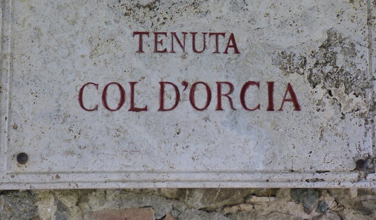 Sign on wall white with red lettering Tenuta Col d'Orcia Tuscany