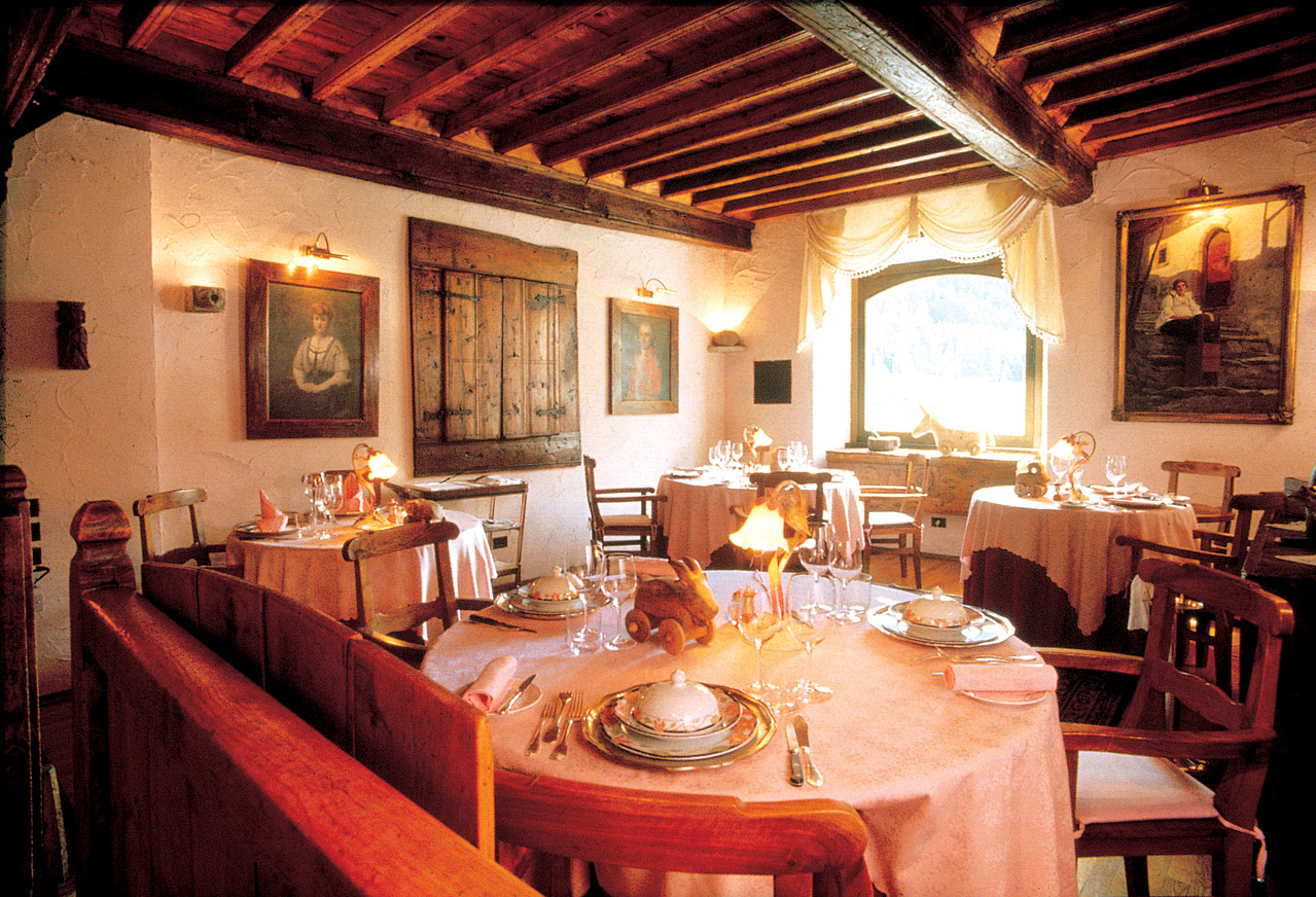 Restaurant indoors with dining tables set up and paintings on the walls