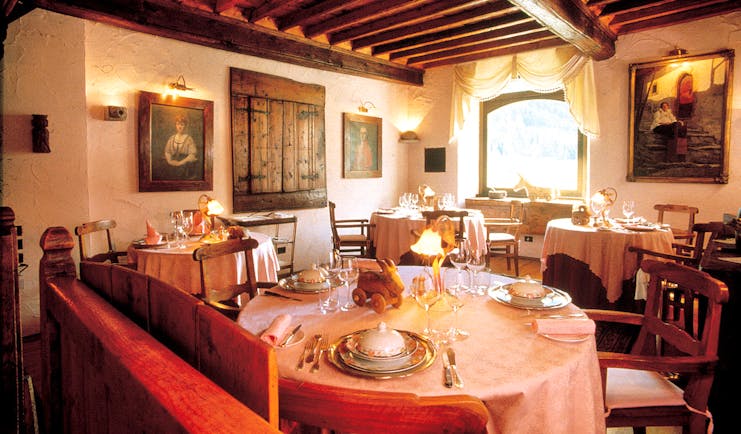 Restaurant indoors with dining tables set up and paintings on the walls