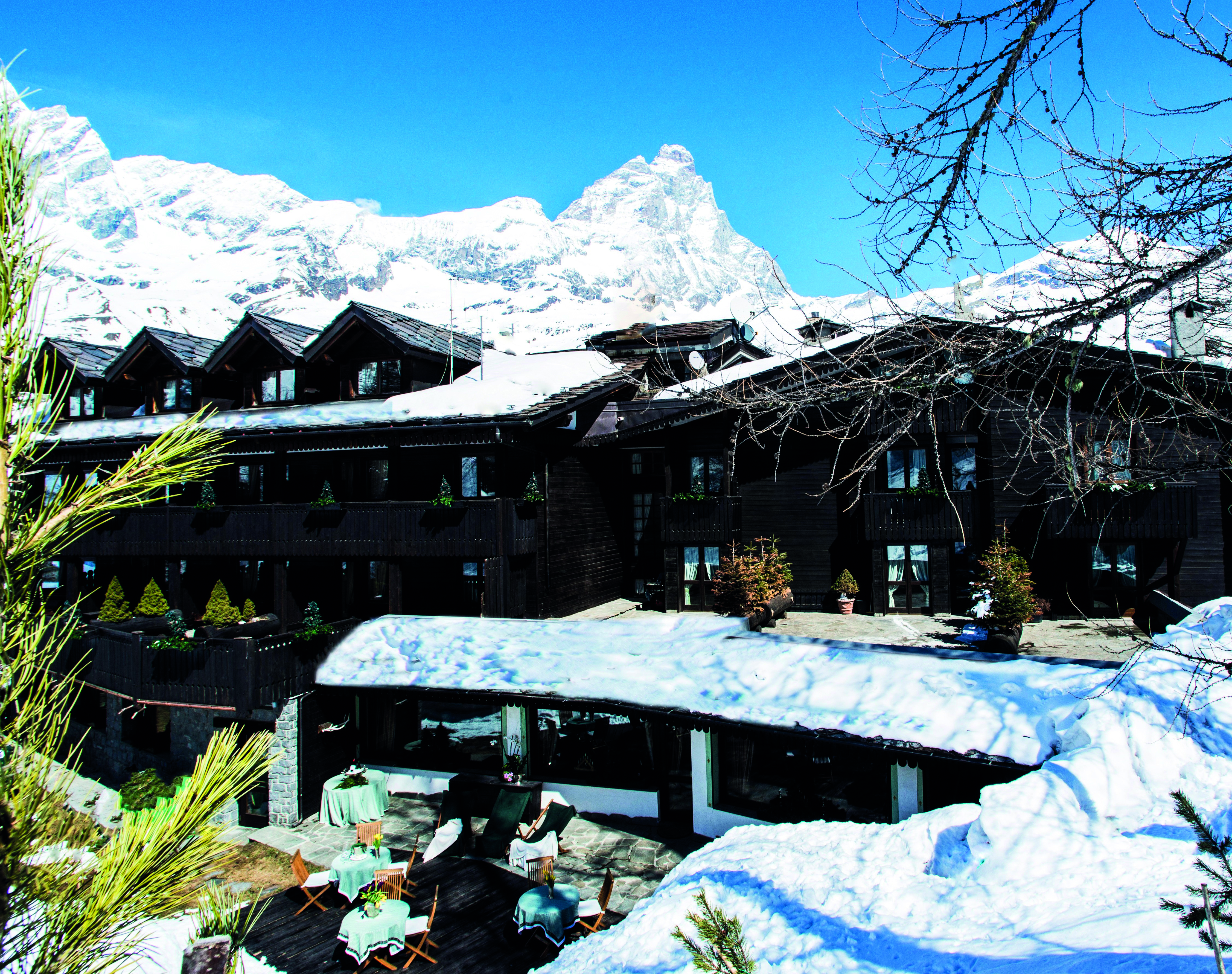 Hotel Hermitage Italy Alps aerial shot of hotel exterior deck chairs on lawn