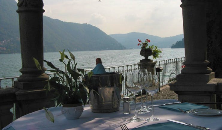 Table set up for dining near to lake with view of water and mountains 