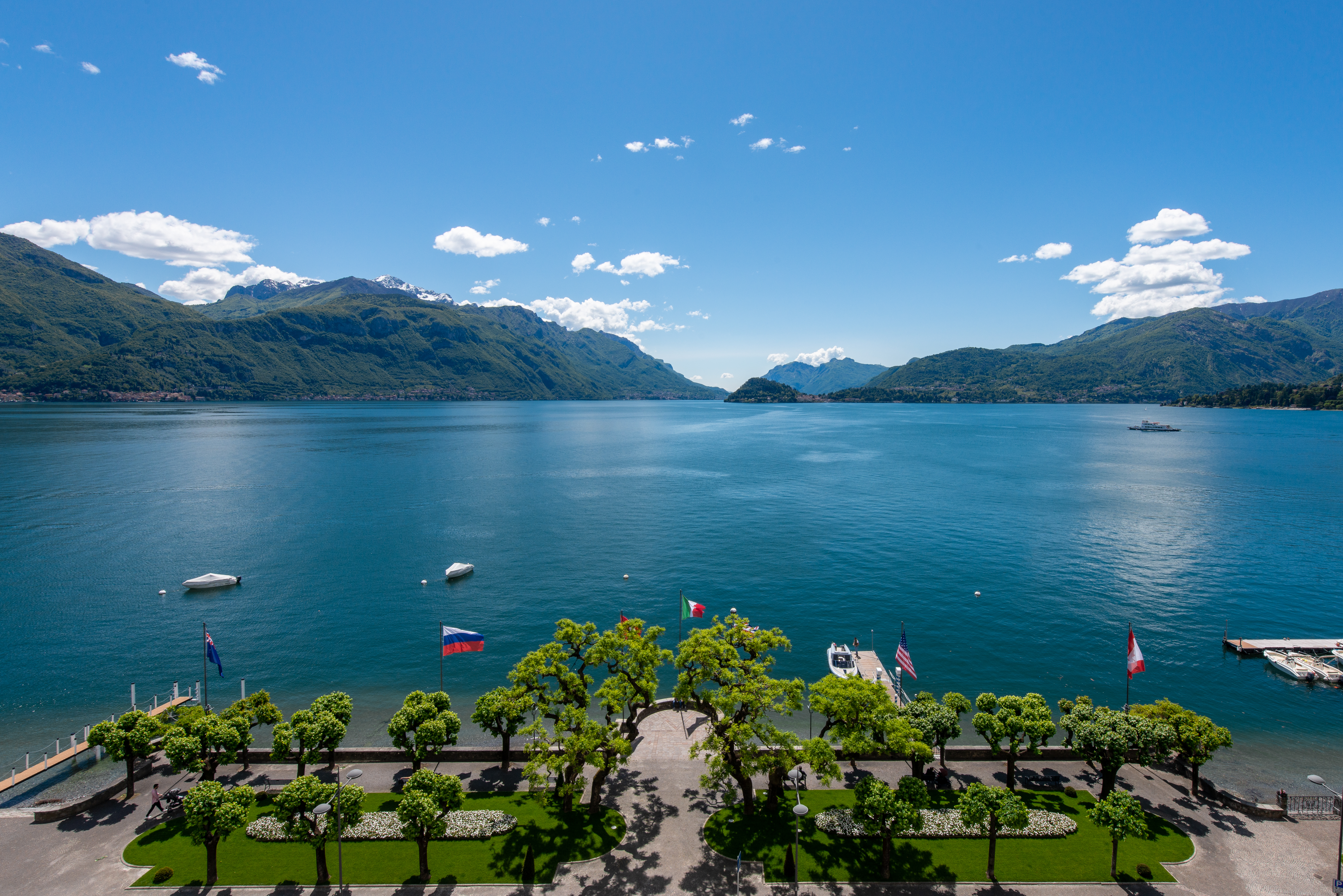 Grand Hotel Victoria Concept & Spa view from the tree-lined promenade out across Lake Como, with green hilly shores