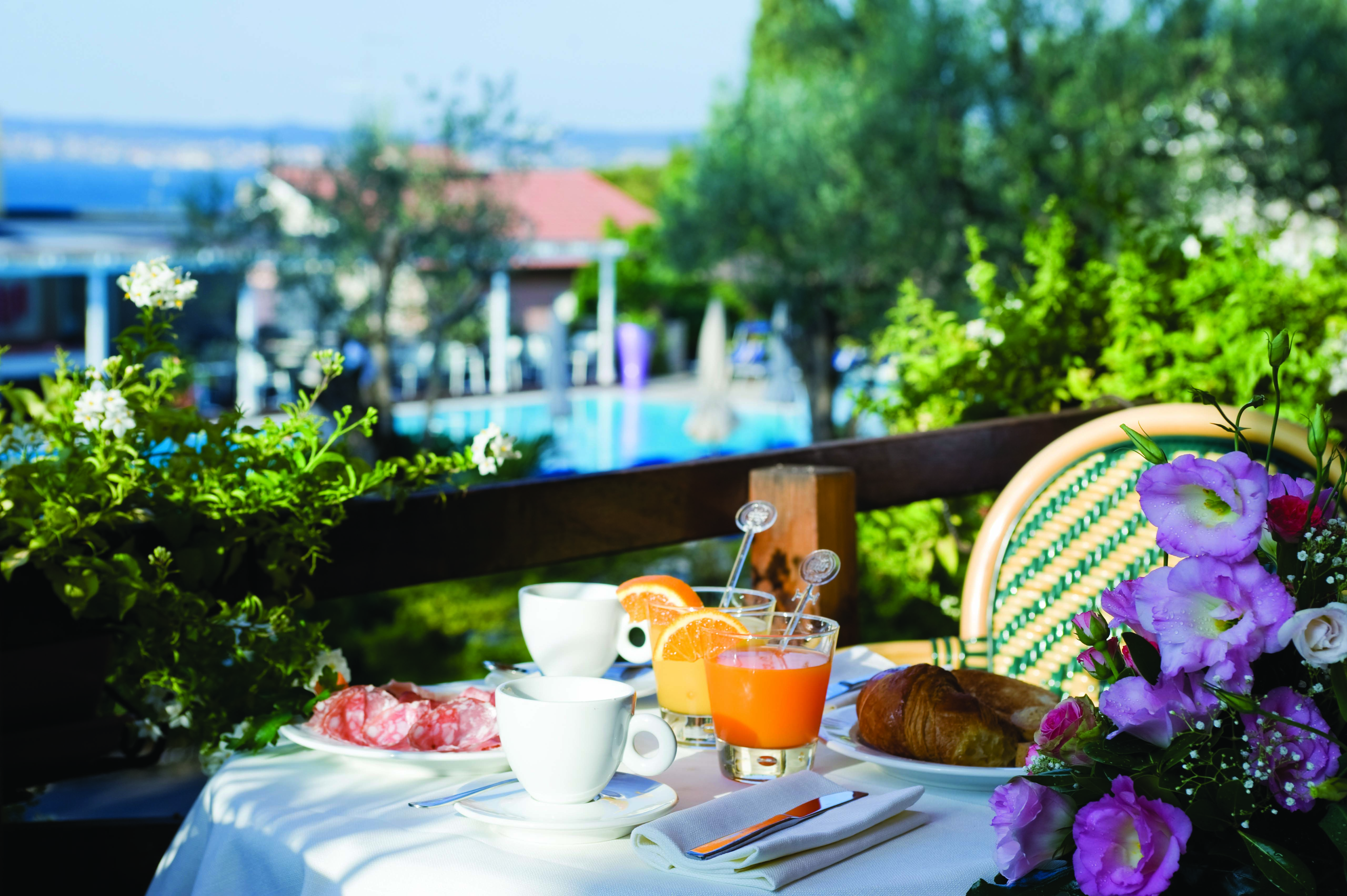 Breakfast layout including cups of tea, orange juice, pastries and a selection of meat